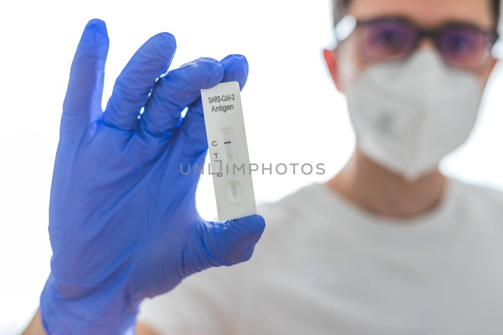 Close up of antigen corona or covid-19 test in the fingers of a young biologist or pharmacist