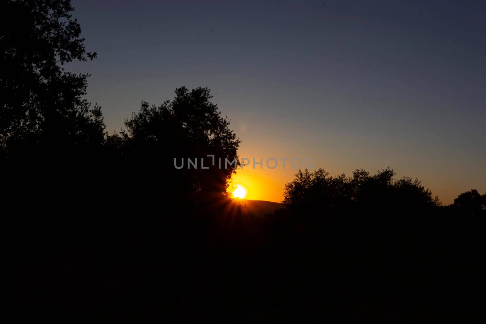 Backlit sunset with yellow, red and blue colors in southern Andalusia, Spain