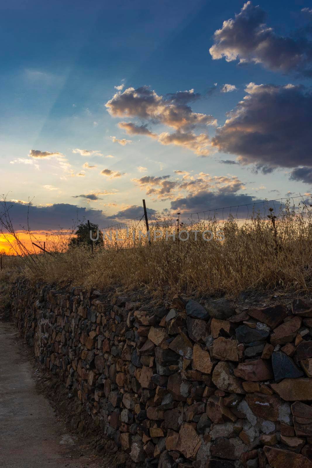 Stone wall in a field in Andalusia with a sunset sky in Spain