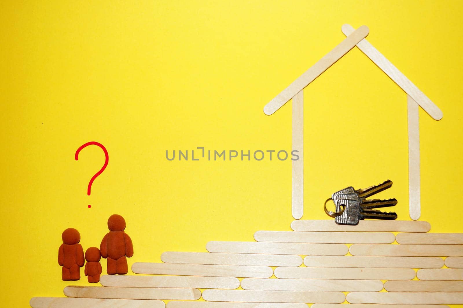 figurines of a man, woman and child climb the stairs, there is a question mark above them, to the house with keys, mortgage concept.