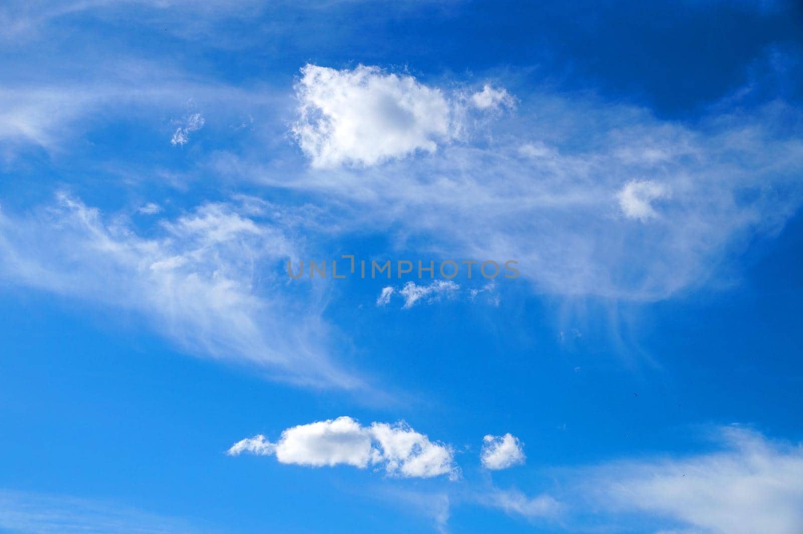 clear blue sky with light white clouds for aerial backdrop.