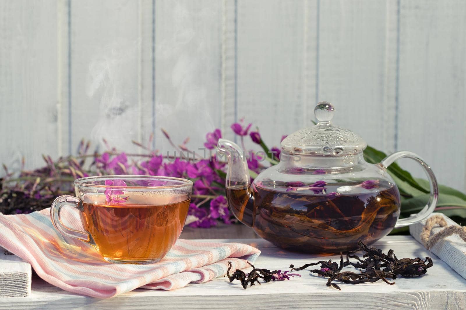 Herbal tea made from fireweed known as blooming sally in teapot and cup, copy space.