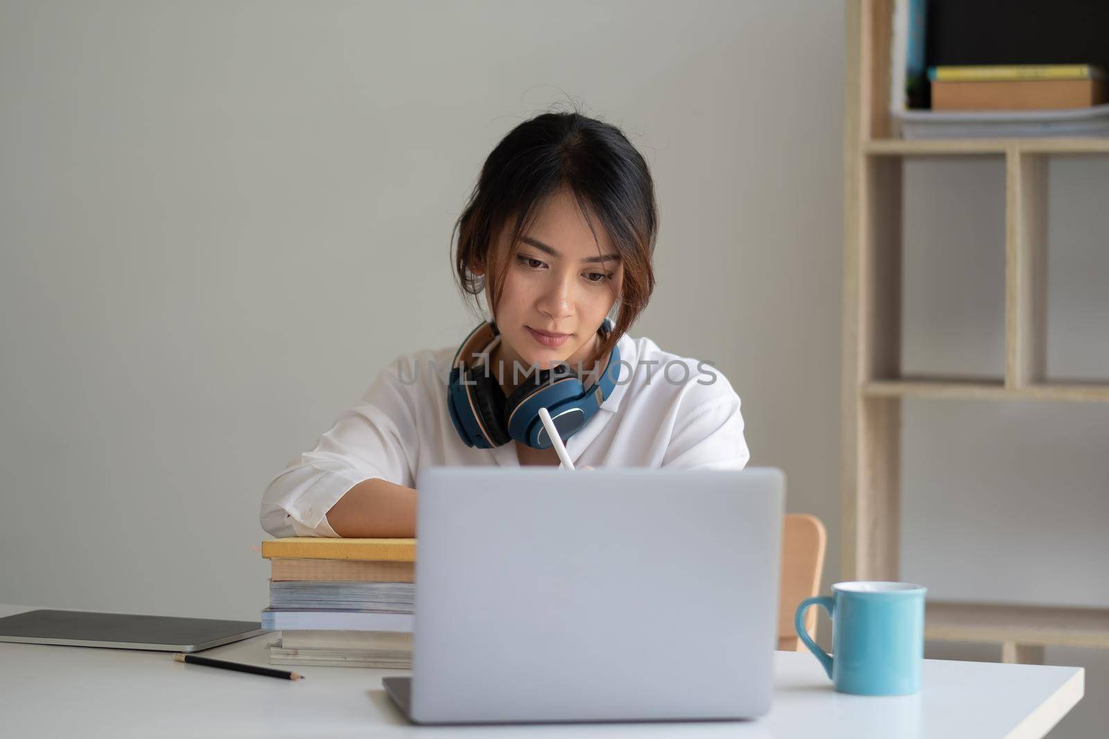 Young asian woman student study at home using laptop and learning online.