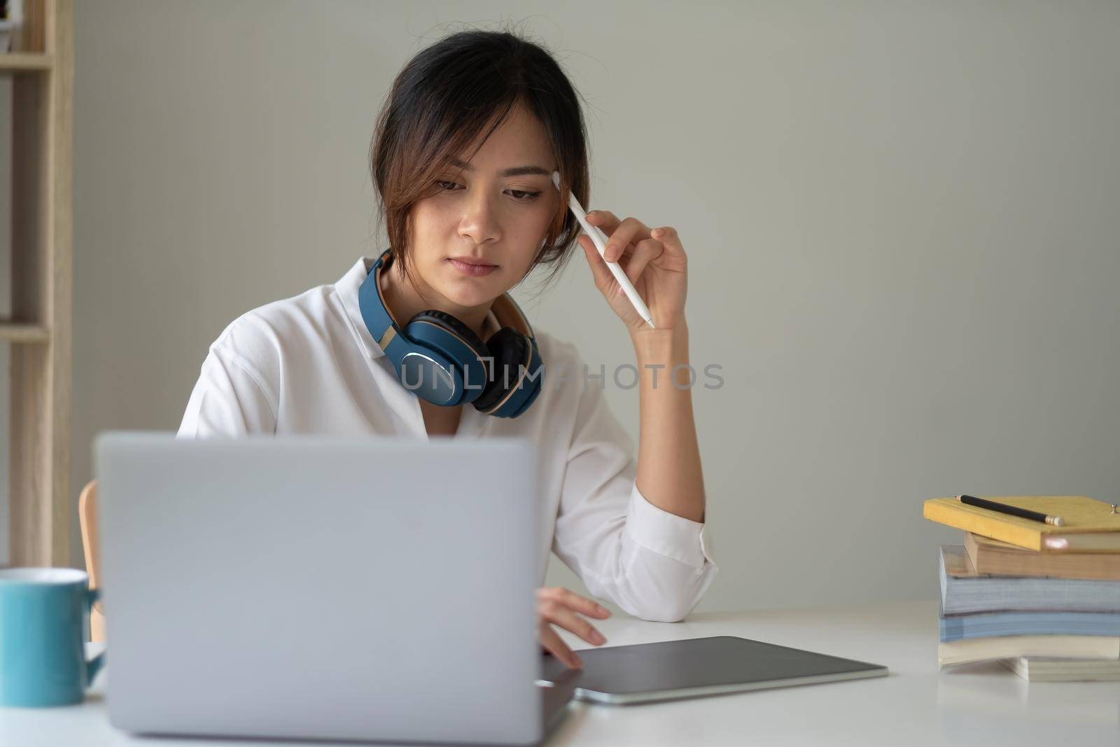 Young asian woman student study at home using laptop and learning online.
