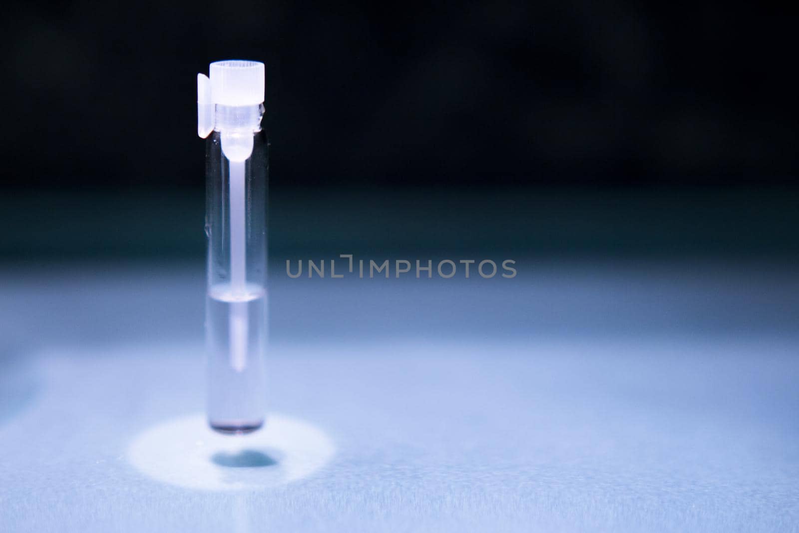 Glass bottle with perfume sample. No people. Copy space