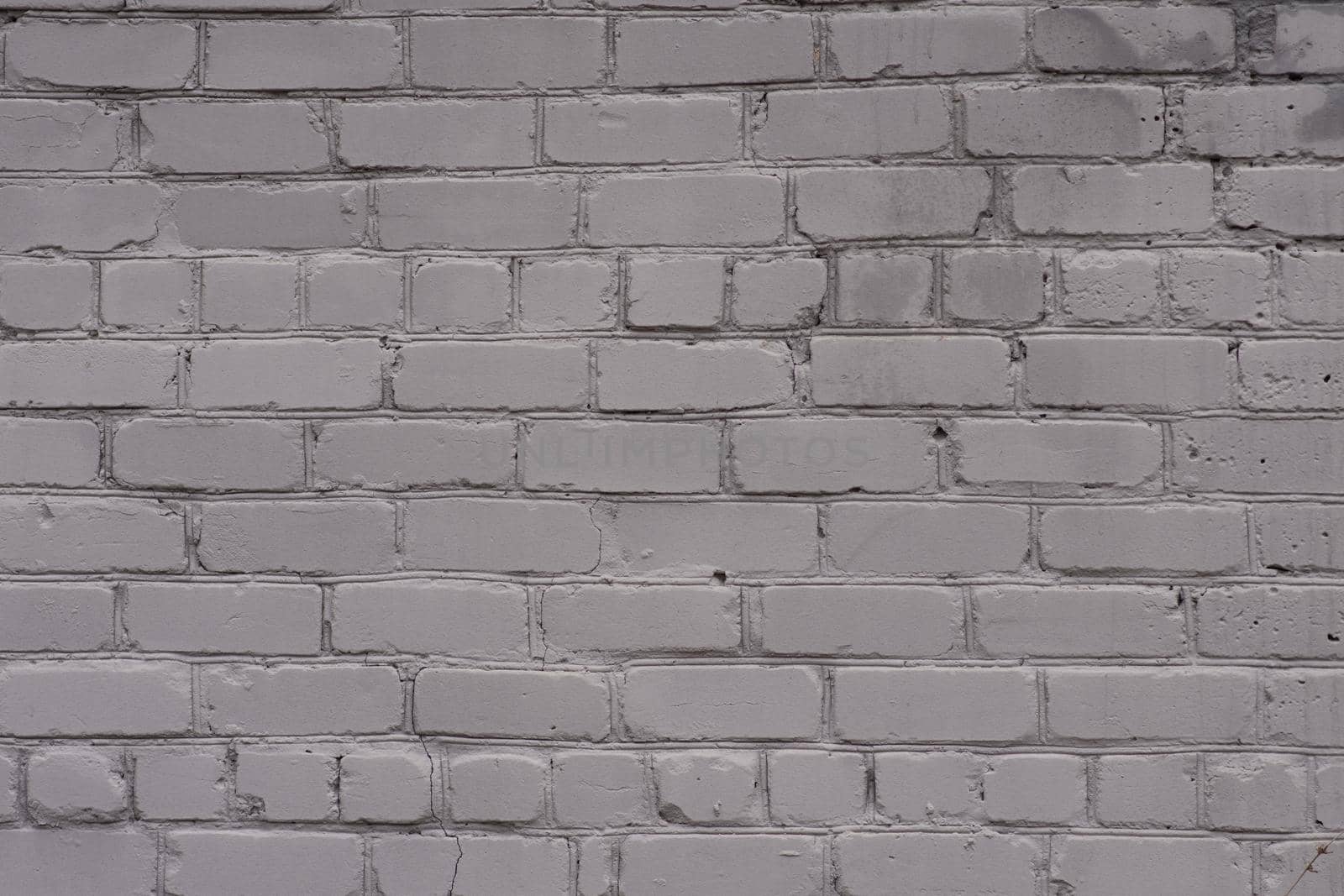 Old brick wall, painted gray. close-up. The view from the street.
