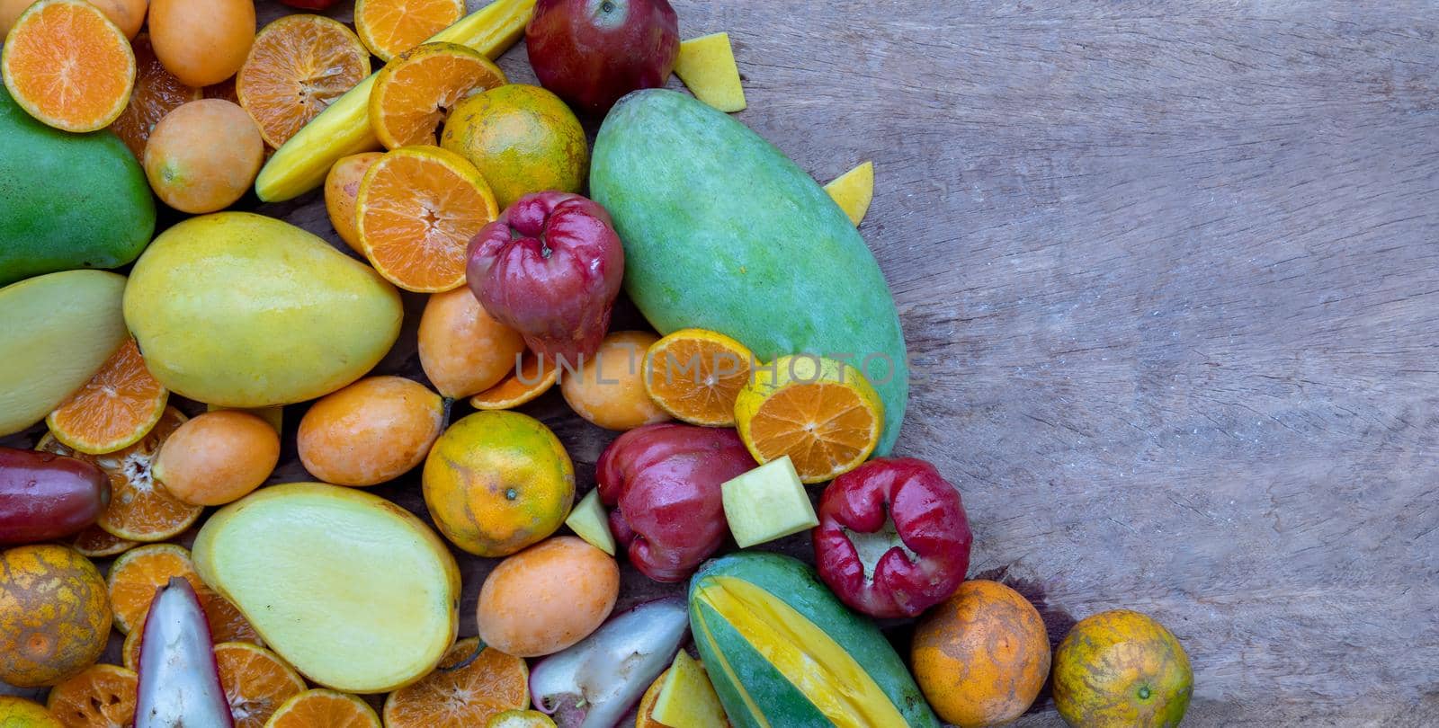 Variety of fresh assorted fruits on the old wooden table. Assorted fruits colorful background, healthy fruits, Copy spce, Selective focus.