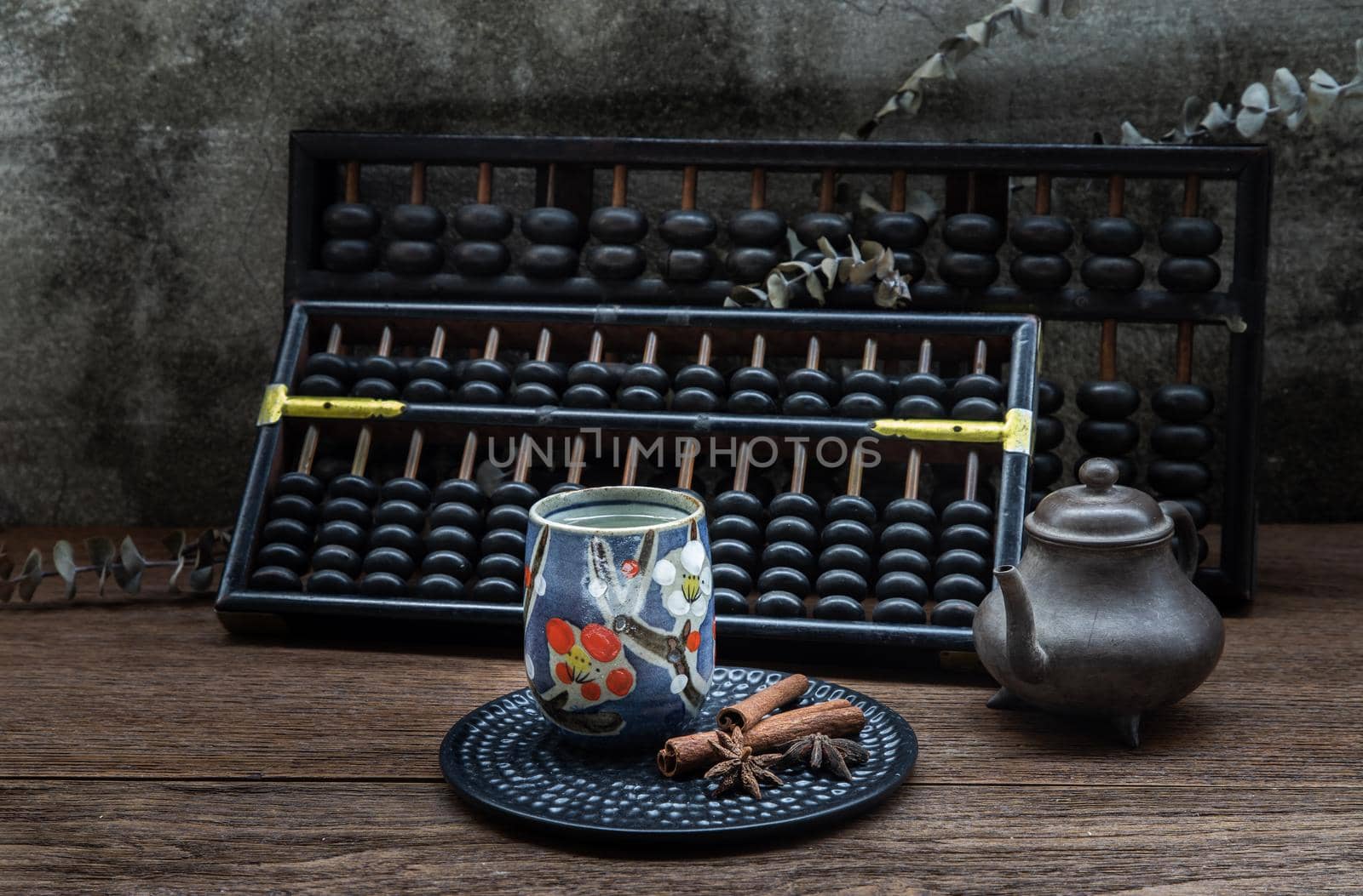 Chinese herbal tea and Vintage wooden hand abacus over Old wood table. Old chinese style atmosphere. Dark tone, Selective focus.