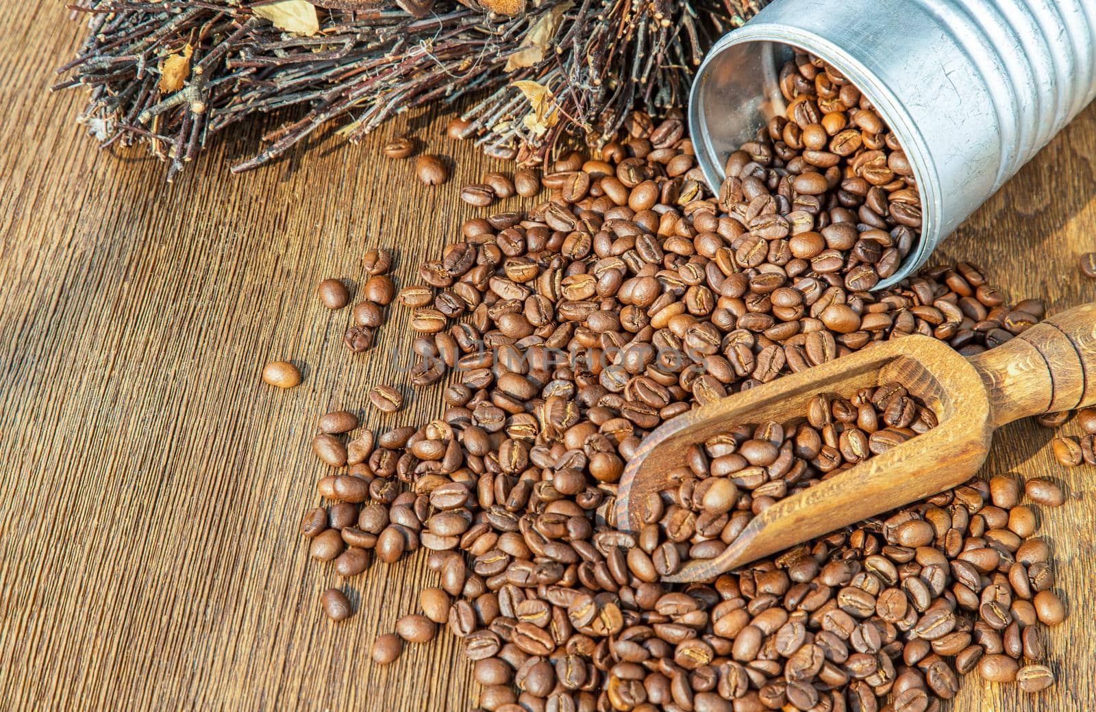 Coffee beans with old wooden scoop Pouring from steel cans roating around on the wooden background with copyspace for your text. Alternative coffee for living life, Coffee style, Selective focus.