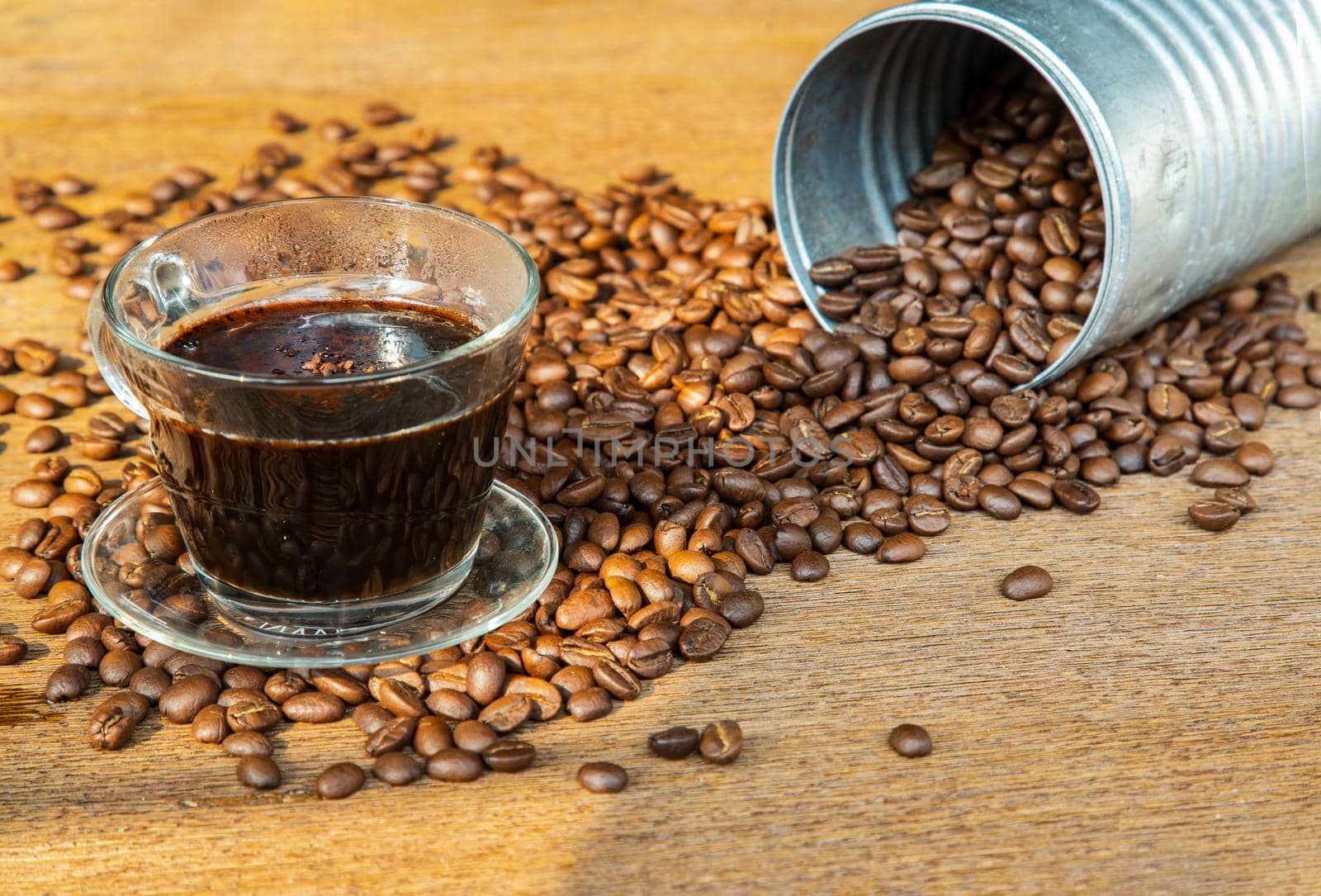 A cup of black coffee and coffee beans roating around on the wooden background with copyspace for your text. Alternative coffee for living life, Coffee style, Selective focus.
