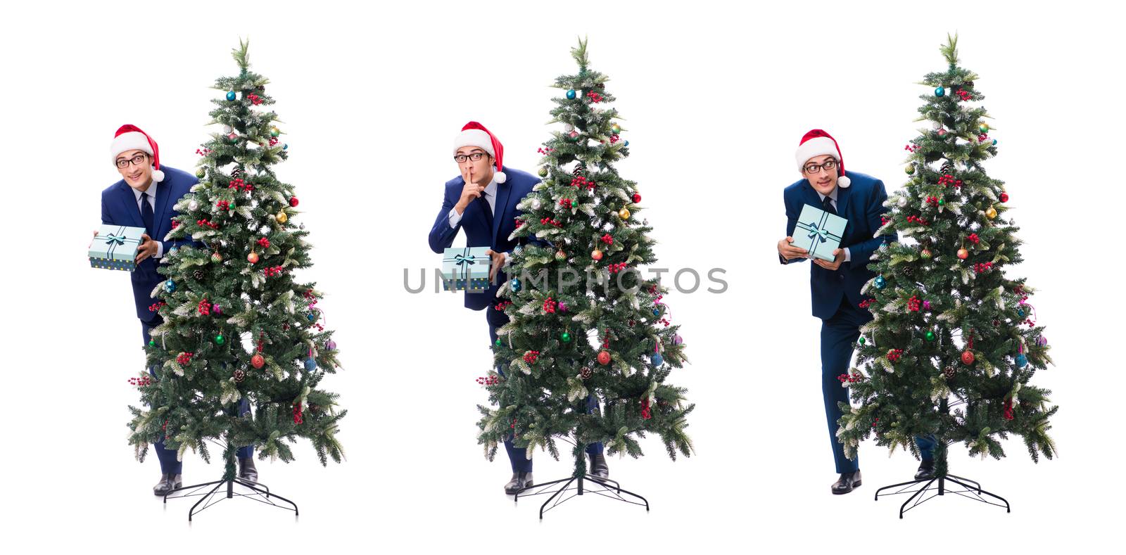Businessman decorating christmas tree isolated on white by Elnur