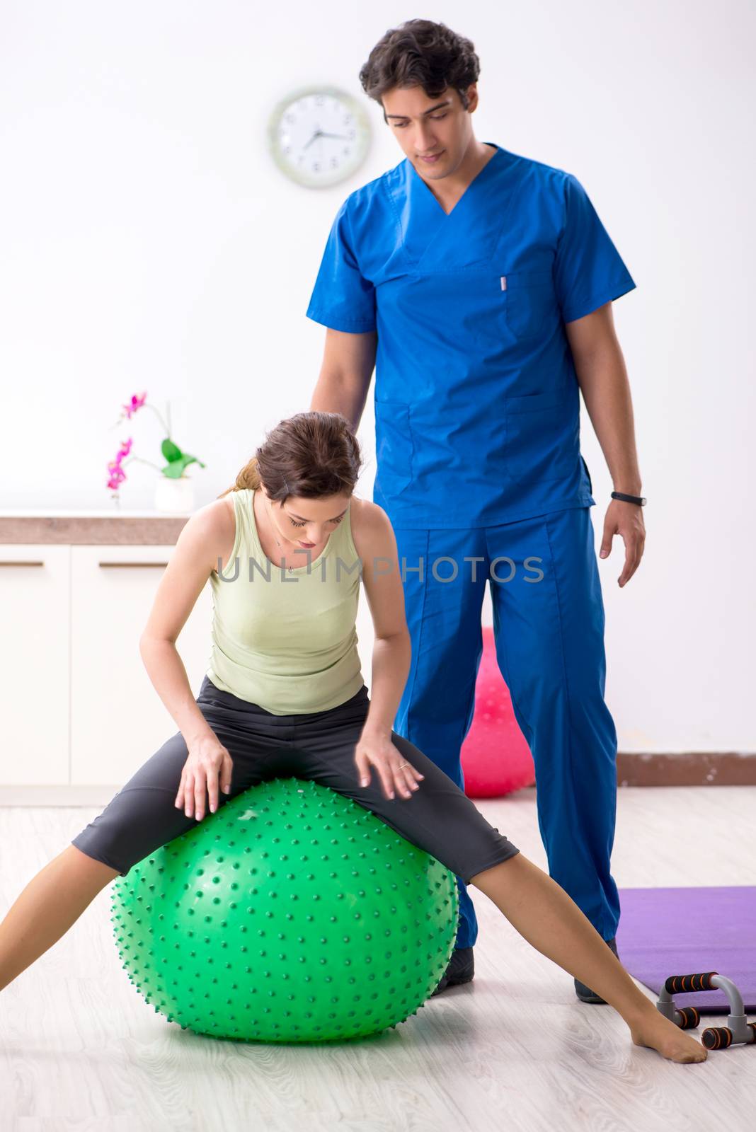 Fitness instructor helping sportsman during exercise