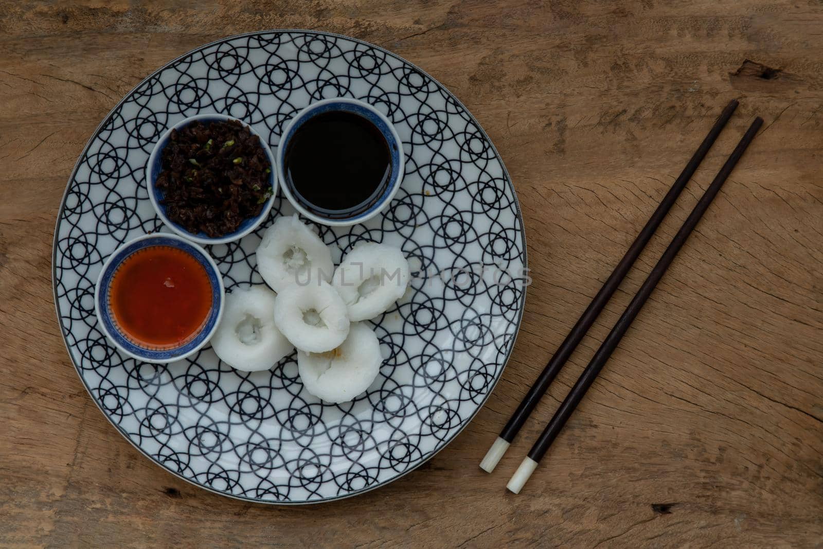 Homemade Chinese Steamed Dumplings with Radish (Jui Guay or Chwee Kueh) aten with pickled turnip, daikon, crumbs, bird's eye chili and black sauce. Copy space, Top view, Selective focus.