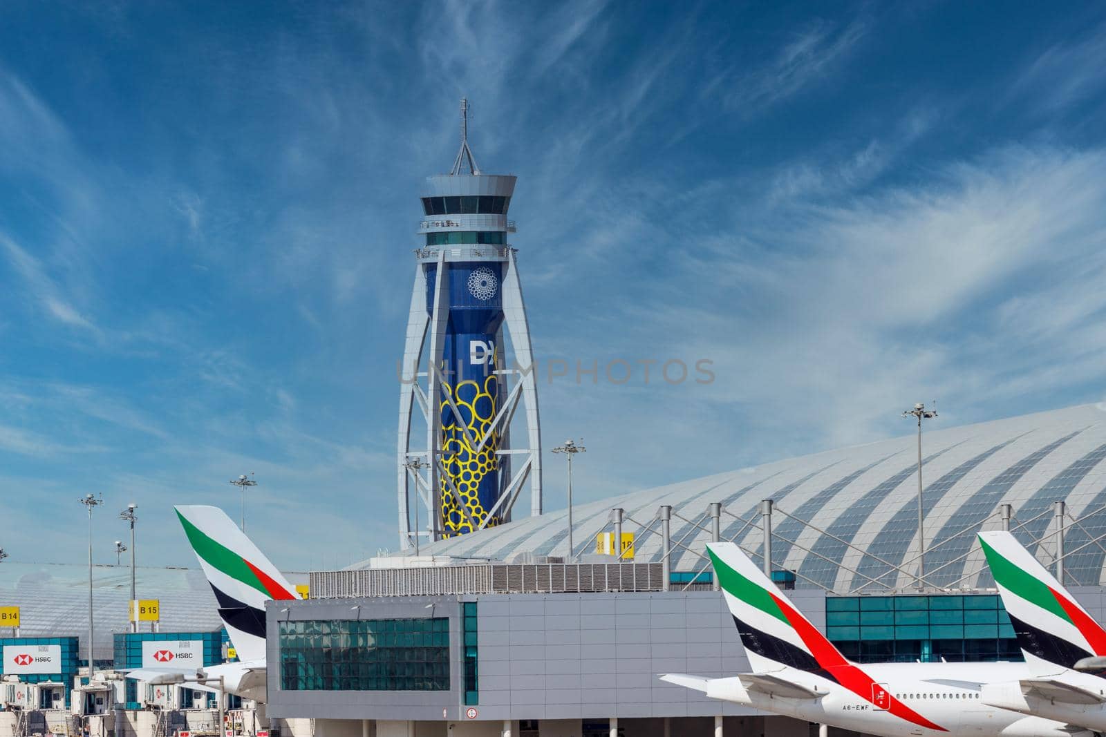 DUBAI, UAE - CIRCA 2021: Emirates Airline Airplanes parked on Dubai Airport, on cloudy sky background. Dubai Airport ATC by dugulan