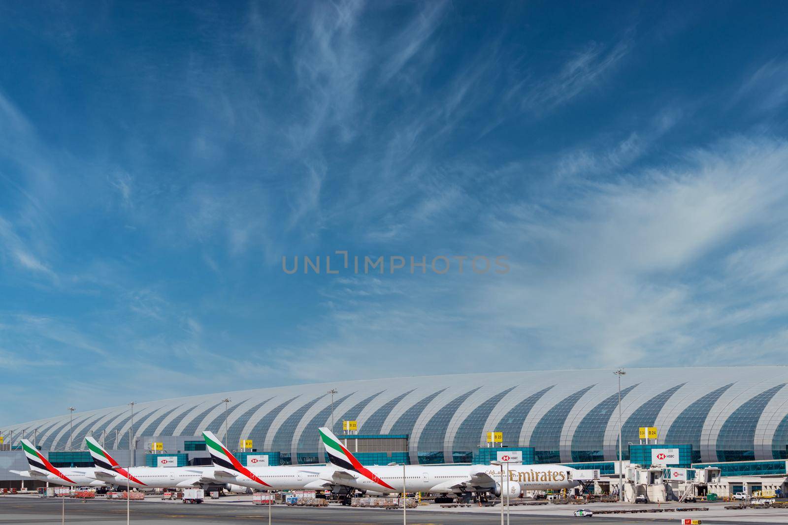 DUBAI, UAE - CIRCA 2021: Emirates Airline Airplanes parked on Dubai Airport, on cloudy sky background.Emirates Airline Airplanes parked on Dubai Airport, on cloudy sky background. by dugulan