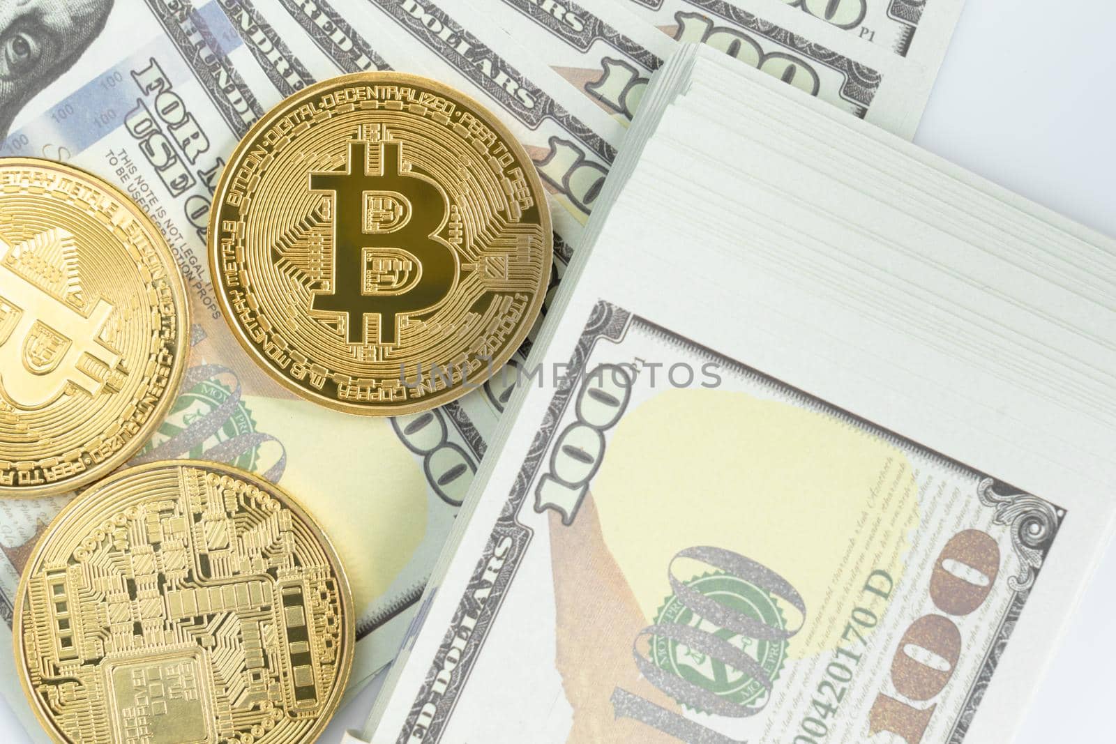 Bitcoins coin and  US banknotes of one hundred dollars. Close up of metal shiny bitcoin crypto currency coins and US dollar
