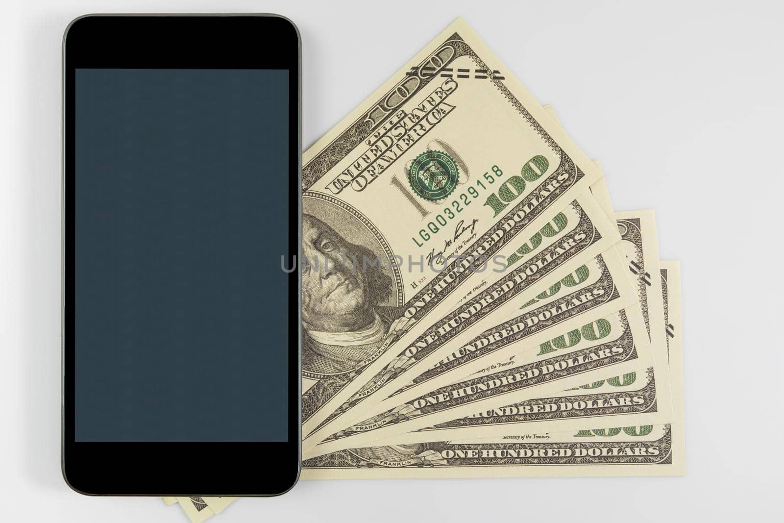 Close up Smartphone on US banknotes of one hundred dollars