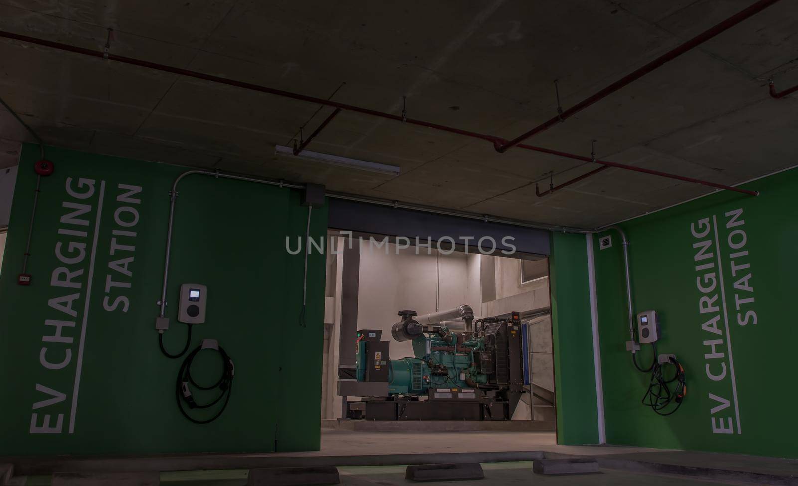 Bangkok, Thailand - 14 Jan 2021 : Front view of Generator Room Emergency power supply with service electric vehicle charging station and battery on the wall outside the room. Selective focus.