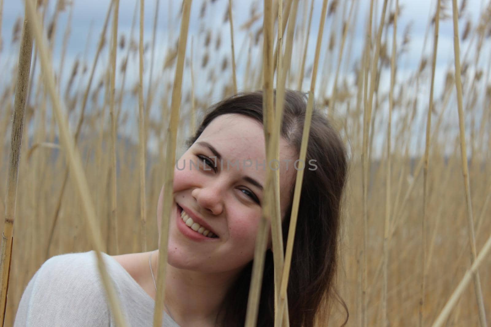 Portrait of a girl of European appearance in nature in a field against the background of high wheat by Olga26