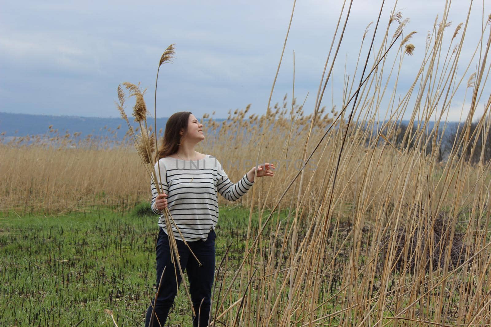 Portrait of a girl of European appearance in nature in a field against the background of high wheat by Olga26