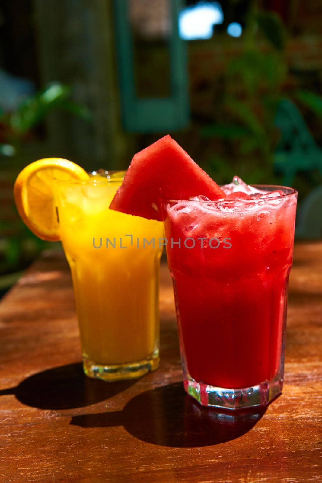 Two glass glasses with refreshing drinks from orange and watermelon juice