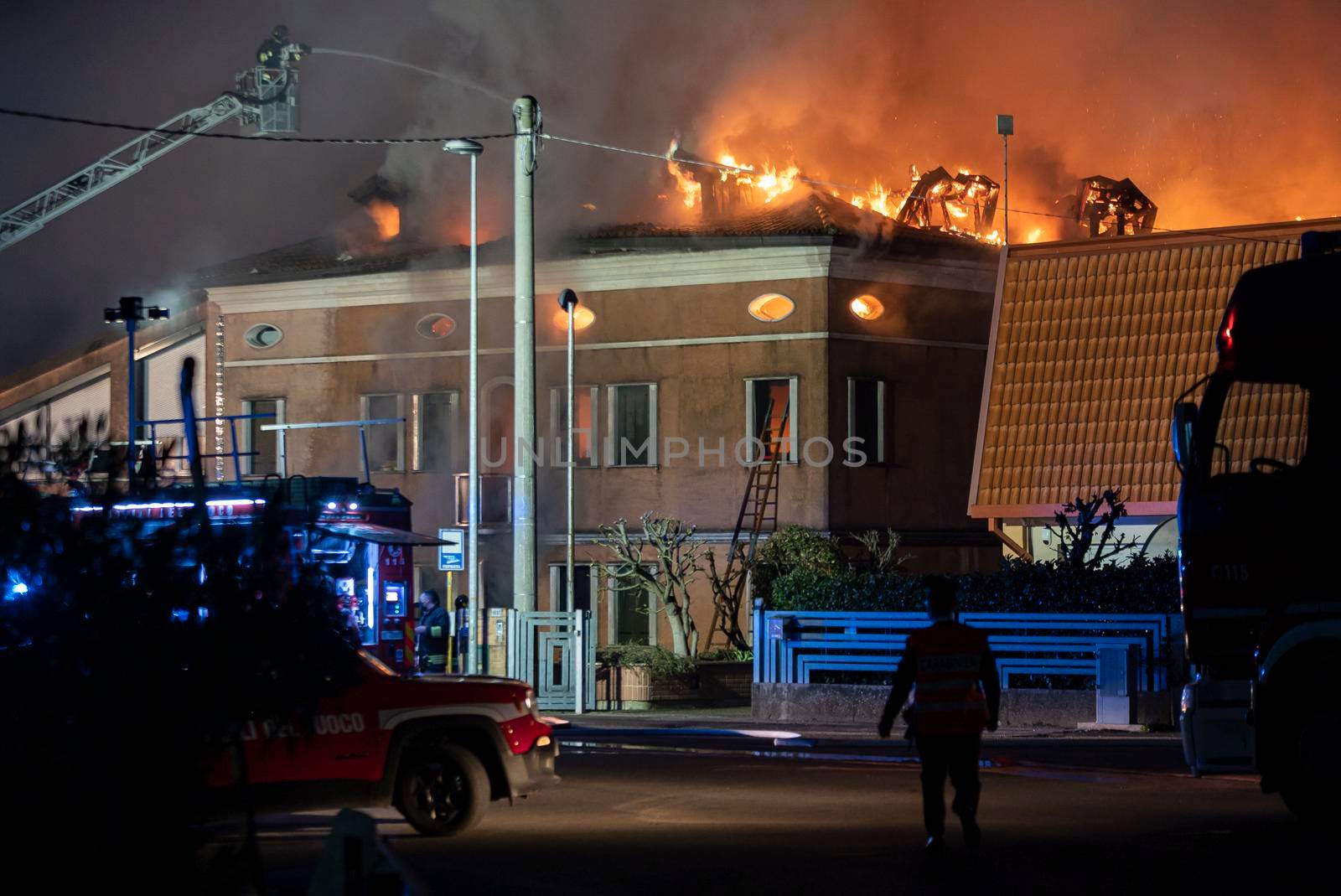 VILLANOVA DEL GHEBBO, ITALY 23 MARCH 2021: House burning at night with firefighters