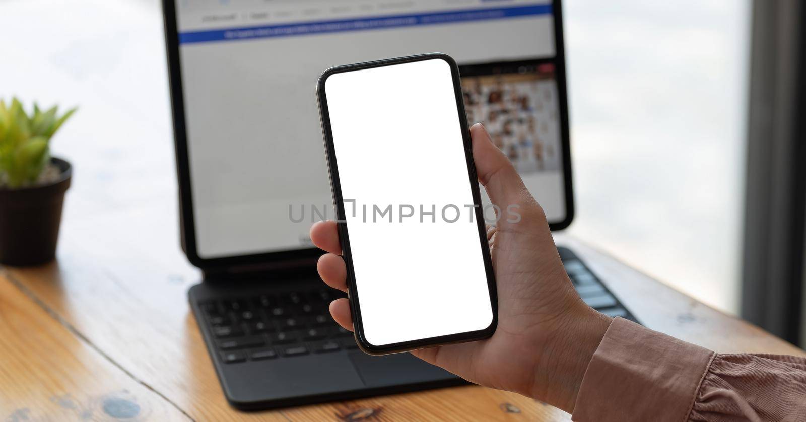 Top view Woman sitting and holding blank screen mock up mobile phone.