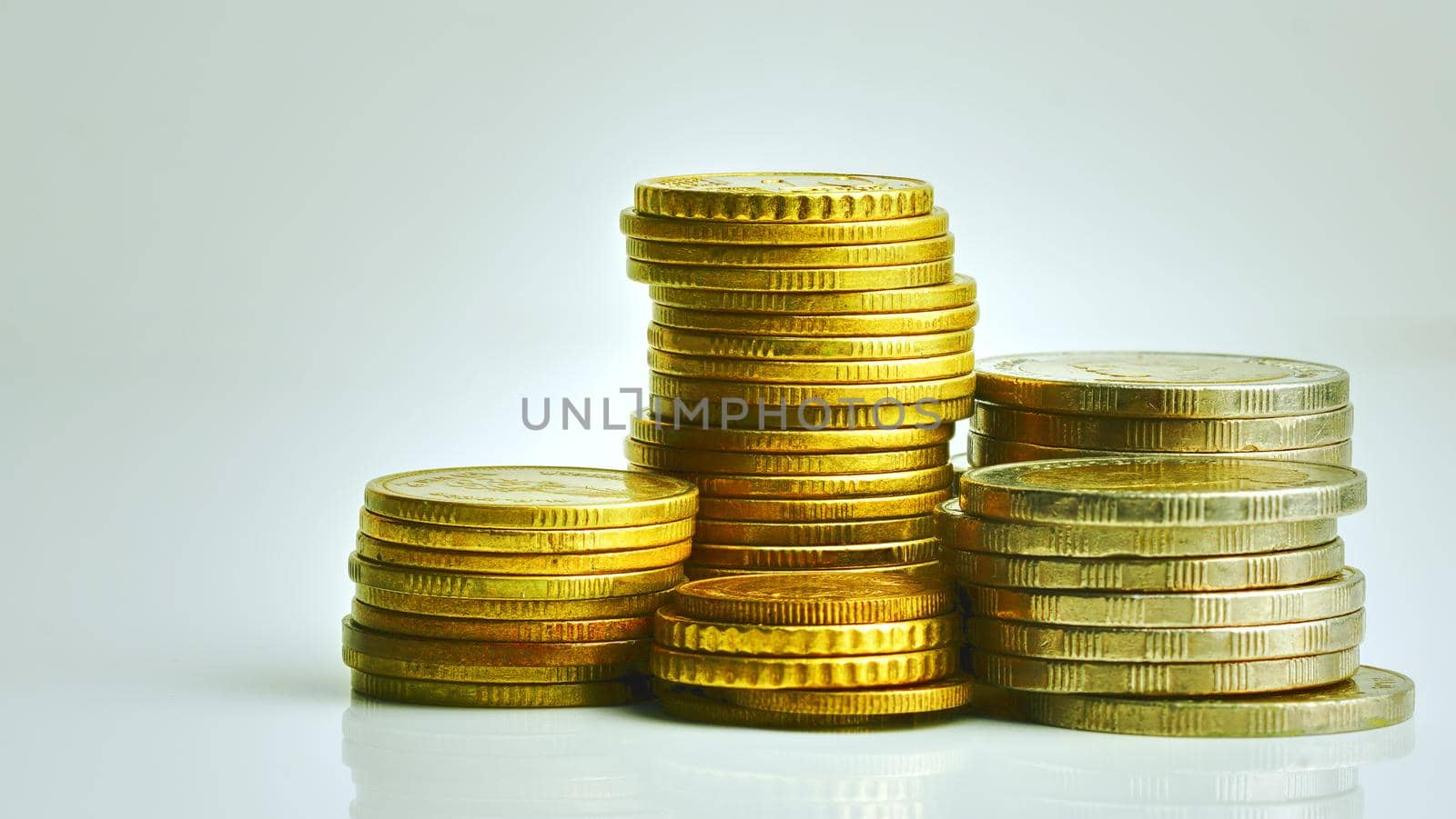 Dollar and Thai baht coins are stacked separately on white background, copy space available. by noppha80