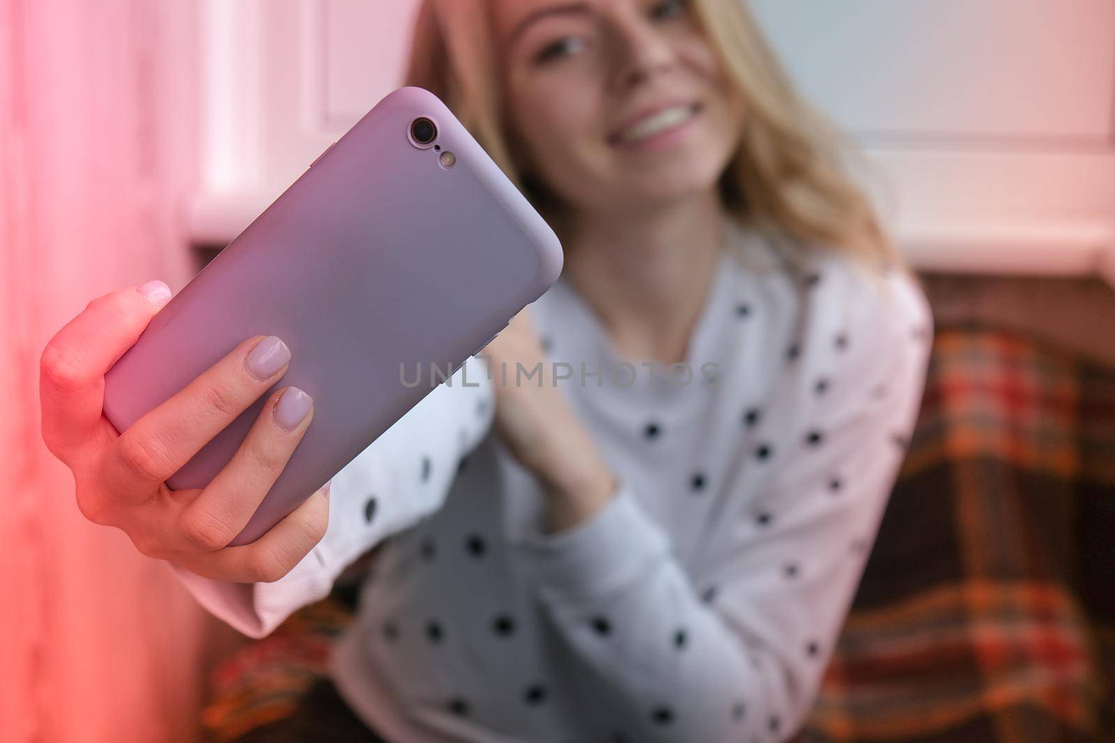 Blonde young girl taking selfie. Video call. Online education. Work from home. Woman holding smartphone. Phone call. Recording new vlog for her channel. Blogger Conference