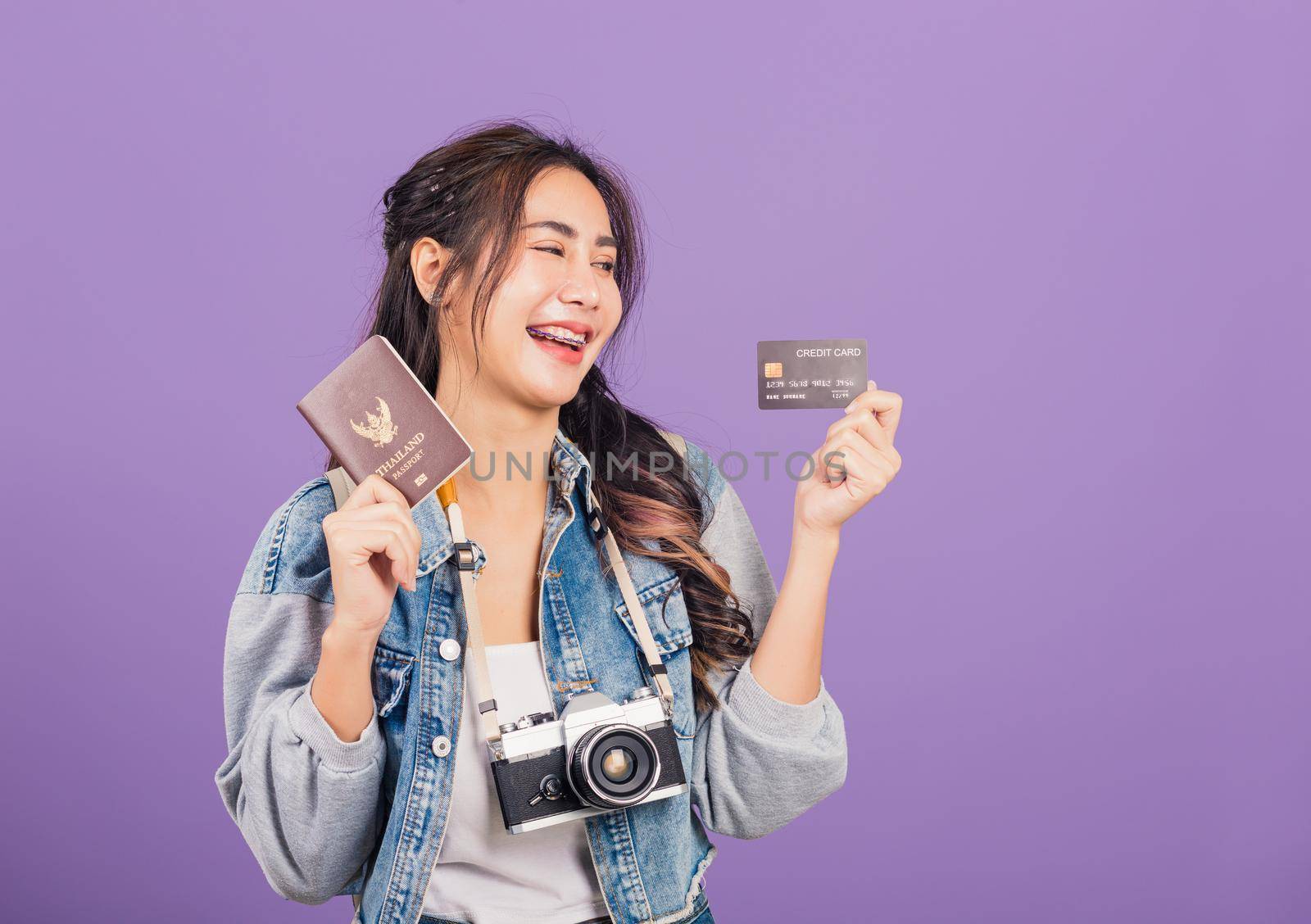woman excited smile in summer holding passport, credit card and vintage photo camera by Sorapop