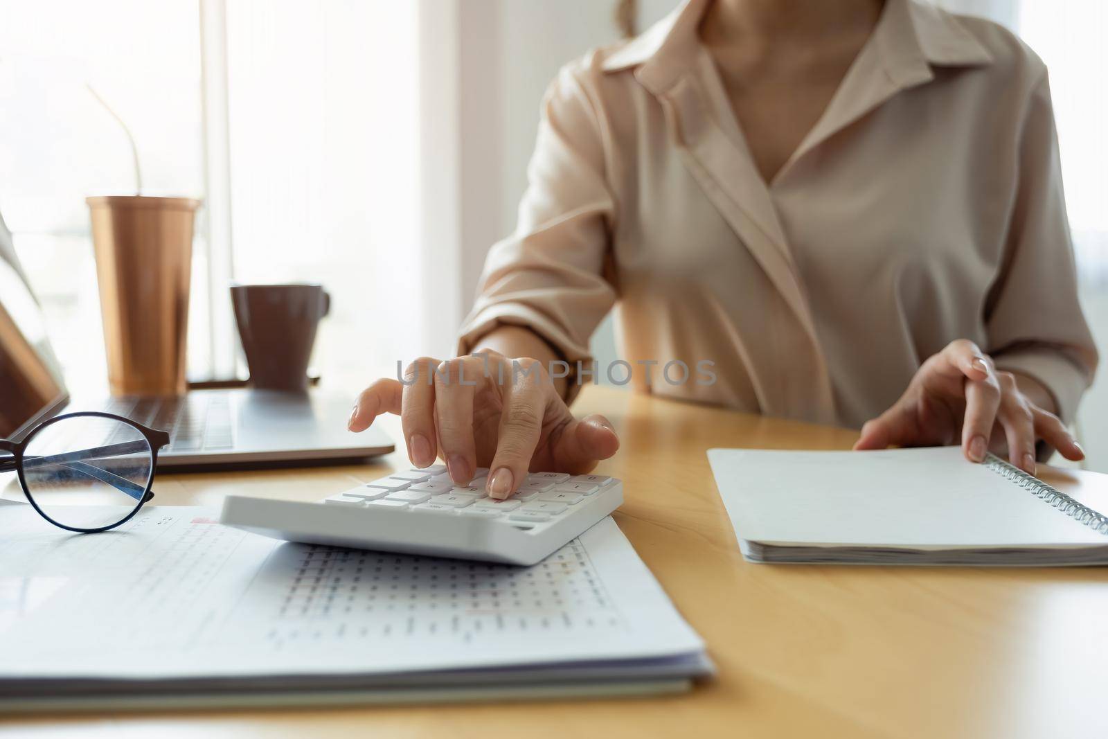 Close up hand of woman using computer calculating household finances or taxes on machine, female manage home family expenditures, using calculator, make payment on laptop.