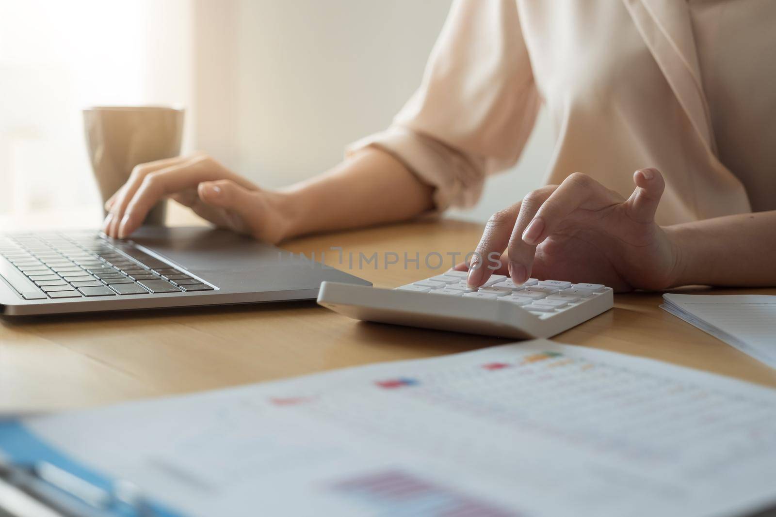 Close up hand of woman using computer calculating household finances or taxes on machine, female manage home family expenditures, using calculator, make payment on laptop.