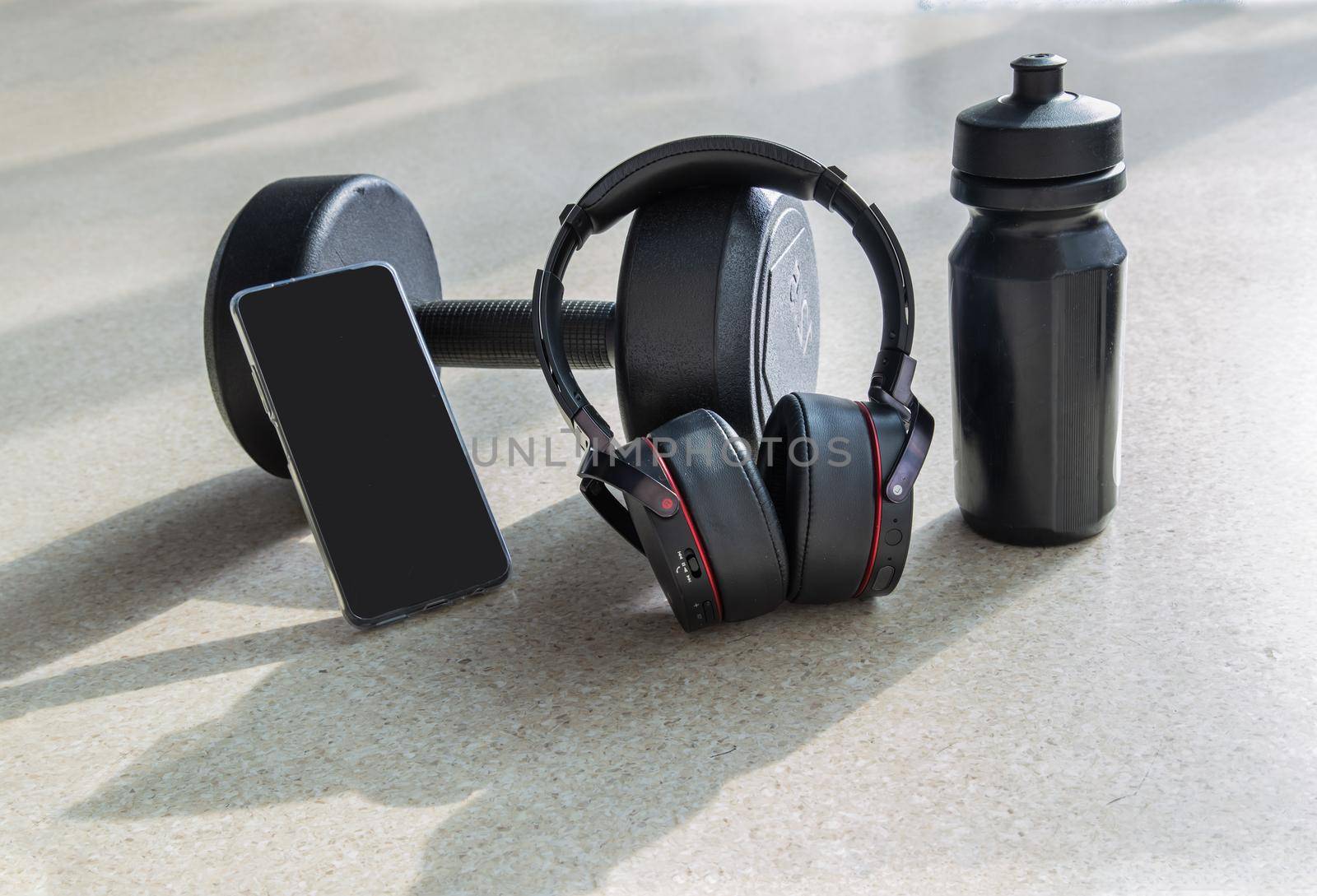 Composition of Smartphone and Headphones, Dumbbell and water bottle for Listening to music while exercising.  by tosirikul