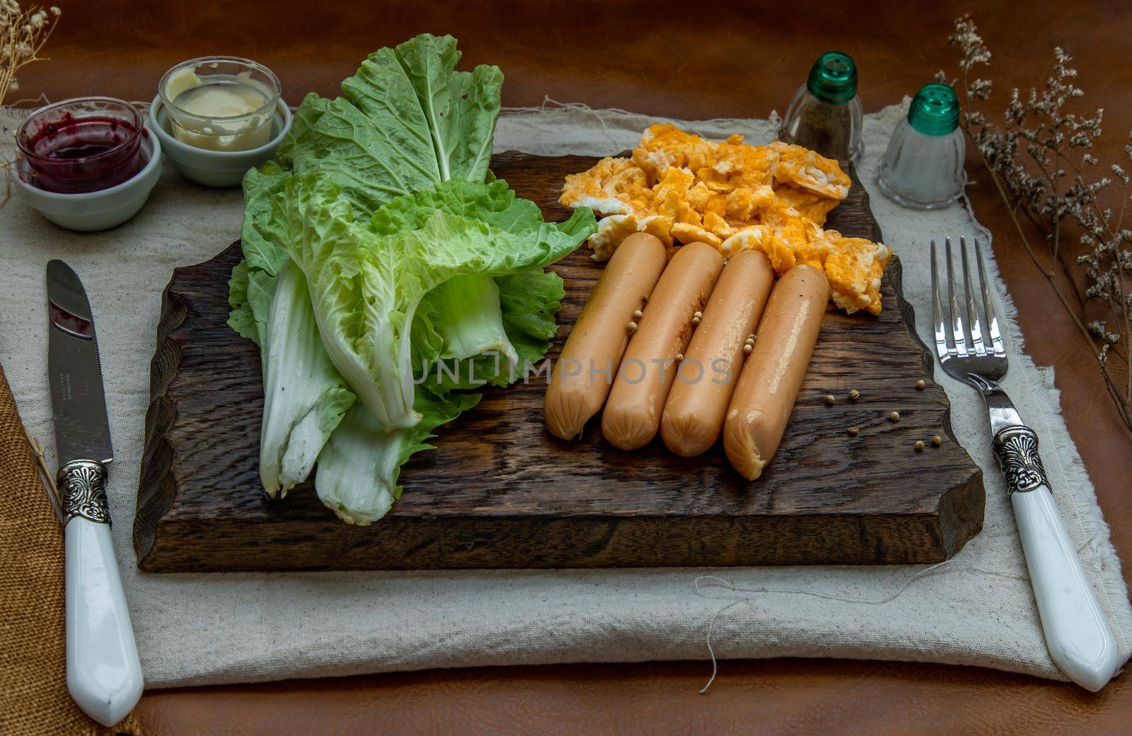 Continental breakfast with scrambled eggs, fried sausages, vegetable and scones on Wooden background, Selective focuse.