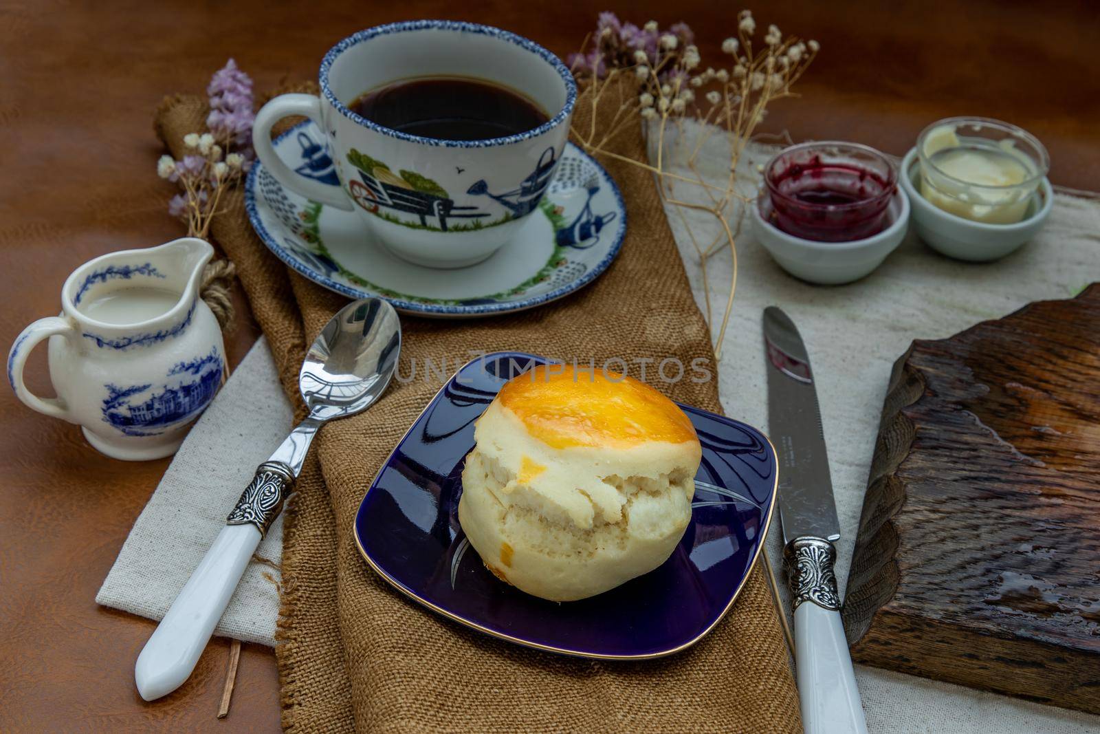 Scones with mascarpone cheese and raspberry jam served with black coffee with milk on sack cloth for new morning. Selective focuse.