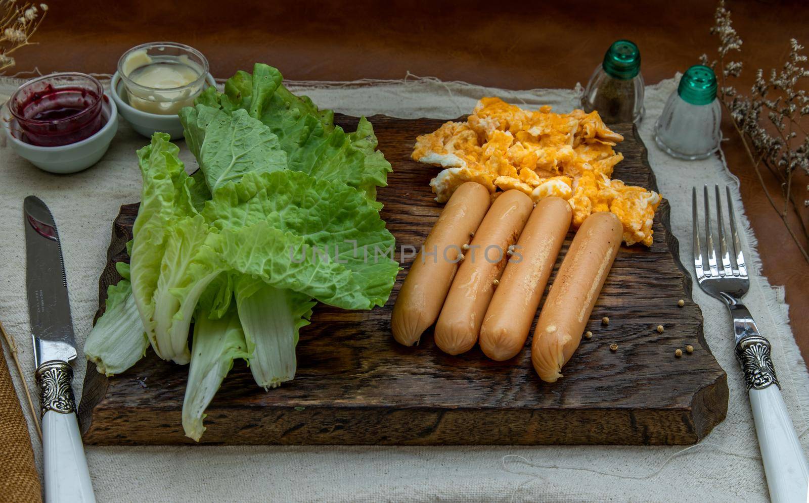 Continental breakfast with scrambled eggs, fried sausages, vegetable and scones on Wooden background, Selective focuse.