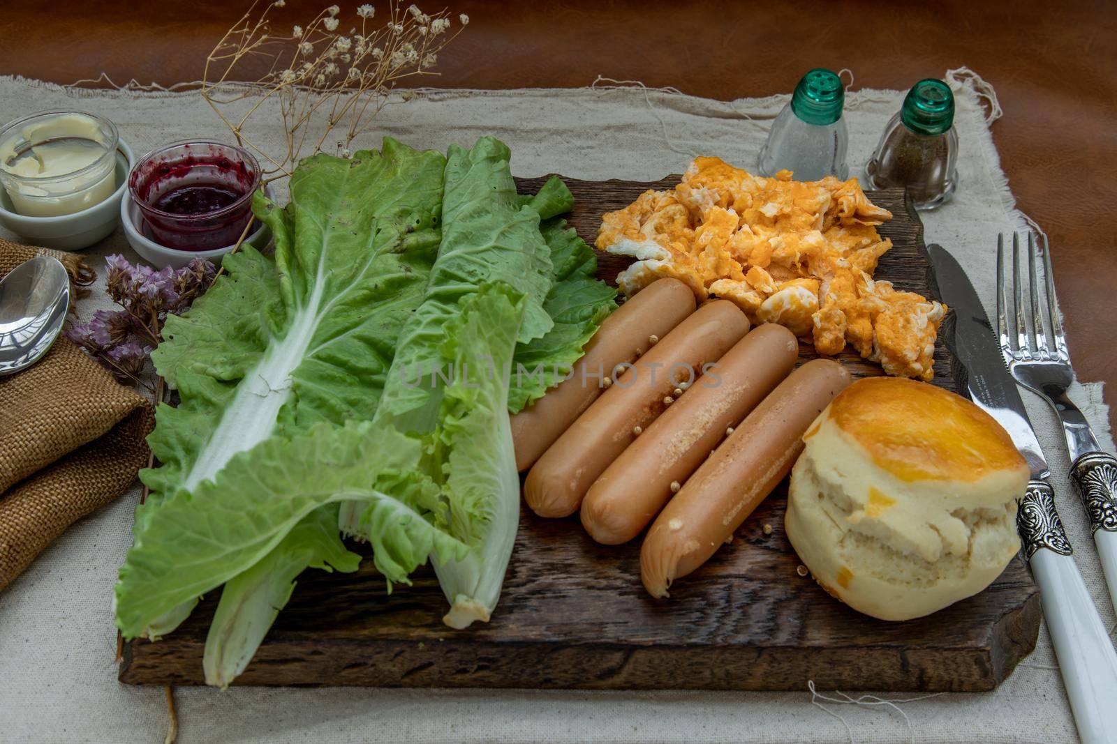 Continental breakfast with scrambled eggs, fried sausages, vegetable and scones on Wooden background, Selective focuse.
