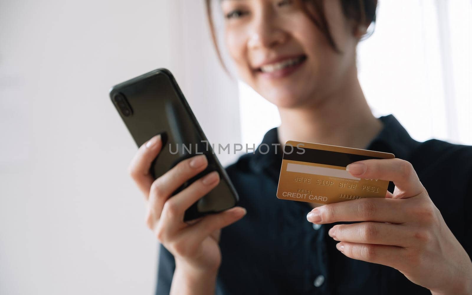 Asian woman making online payment using laptop and credit card for shopping at home. by nateemee