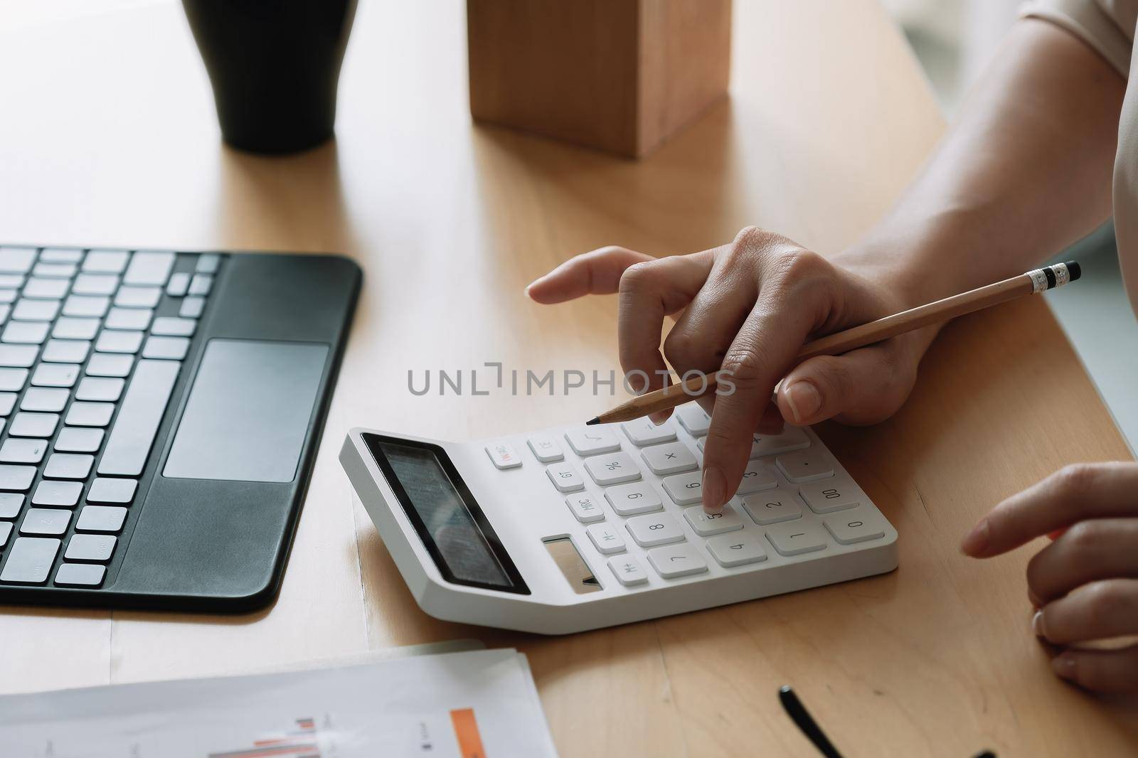 Close up Business woman or accountant using calculator with computer laptop, Business accounting, budget and loan paper at home.