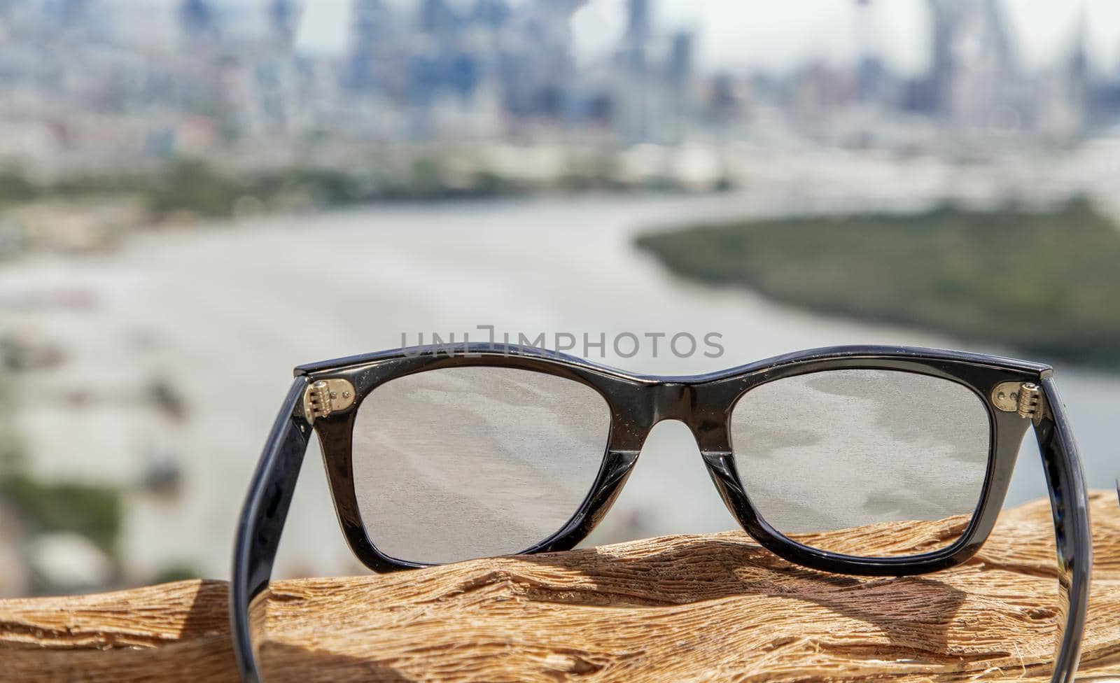 Black eyeglass on a reflective surface. View through the lens of glasses that look at the Chao Phraya River.