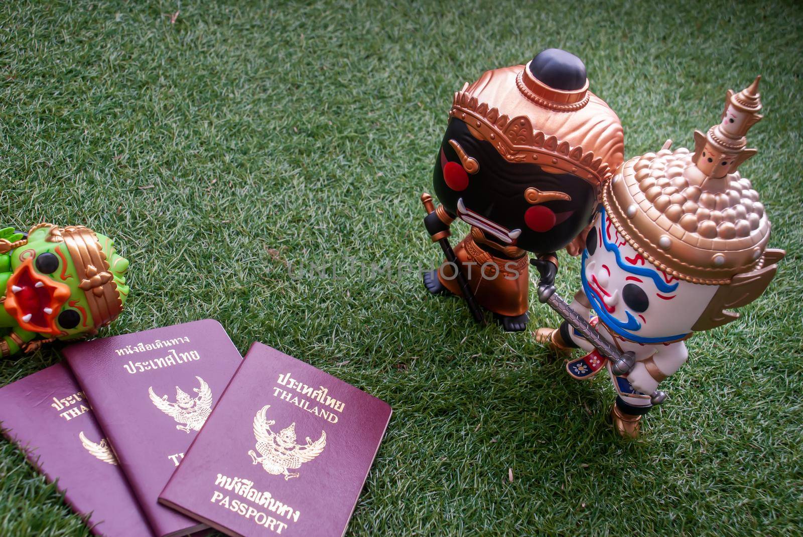 Bangkok, thailand - Nov 22, 2018 : Ravana and giantess  Standing staring at Hanuman sleep side next to passport. Traveller doll. Selective focus.