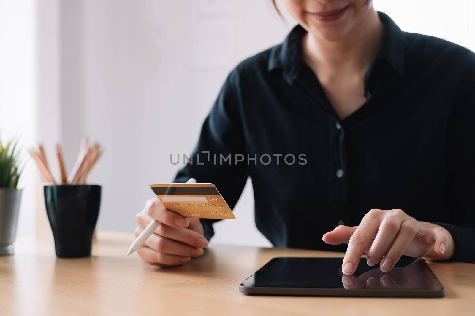 Asian woman making online payment using laptop and credit card for shopping at home. by nateemee