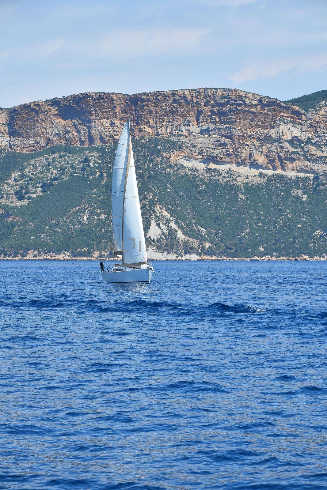 Sailboat in blue sea water by BreakingTheWalls