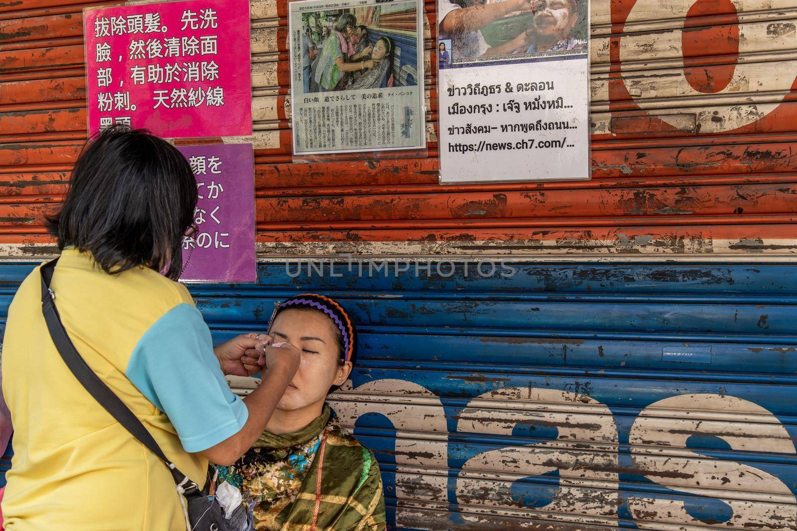 Bangkok, thailand - Feb 16, 2020 : Yaowarat street merchant service customer face hair removal beauty by yarn. Ancient chinese - style hair removal, Chinese traditional “ Mang Ming “ style.