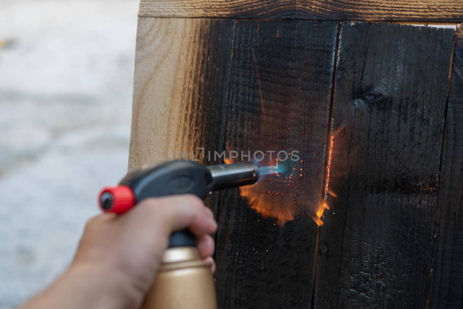 Professional carpenter using old traditional japanese technique. Burning wood planks with gas burner. DIY process.