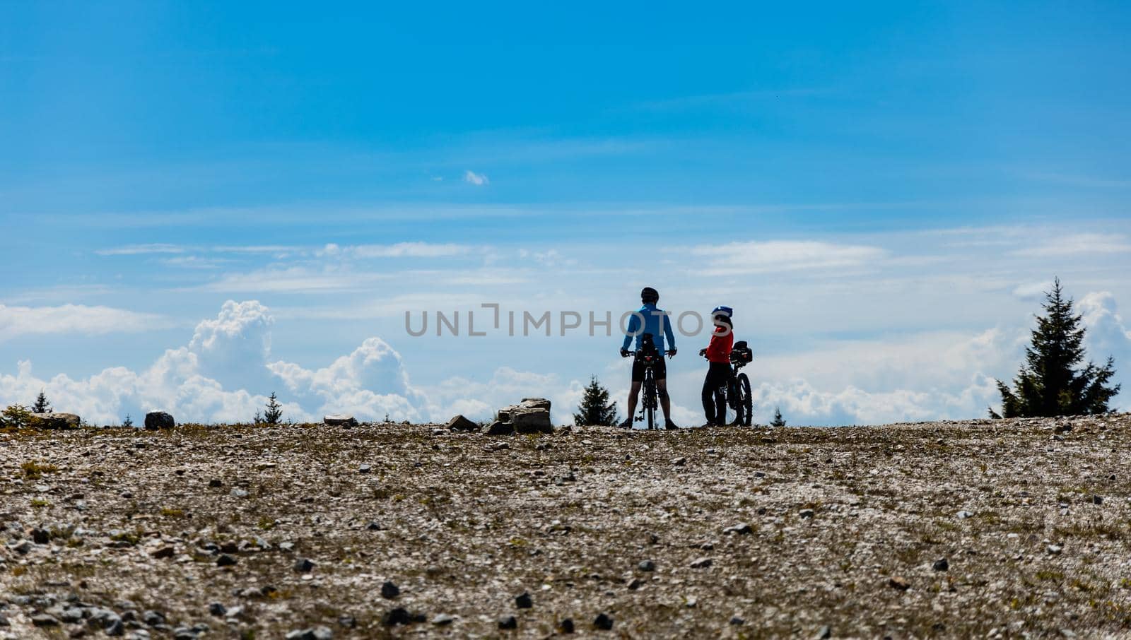 Two people standing with bicycles on the edge of quartz mine at sunny day by Wierzchu