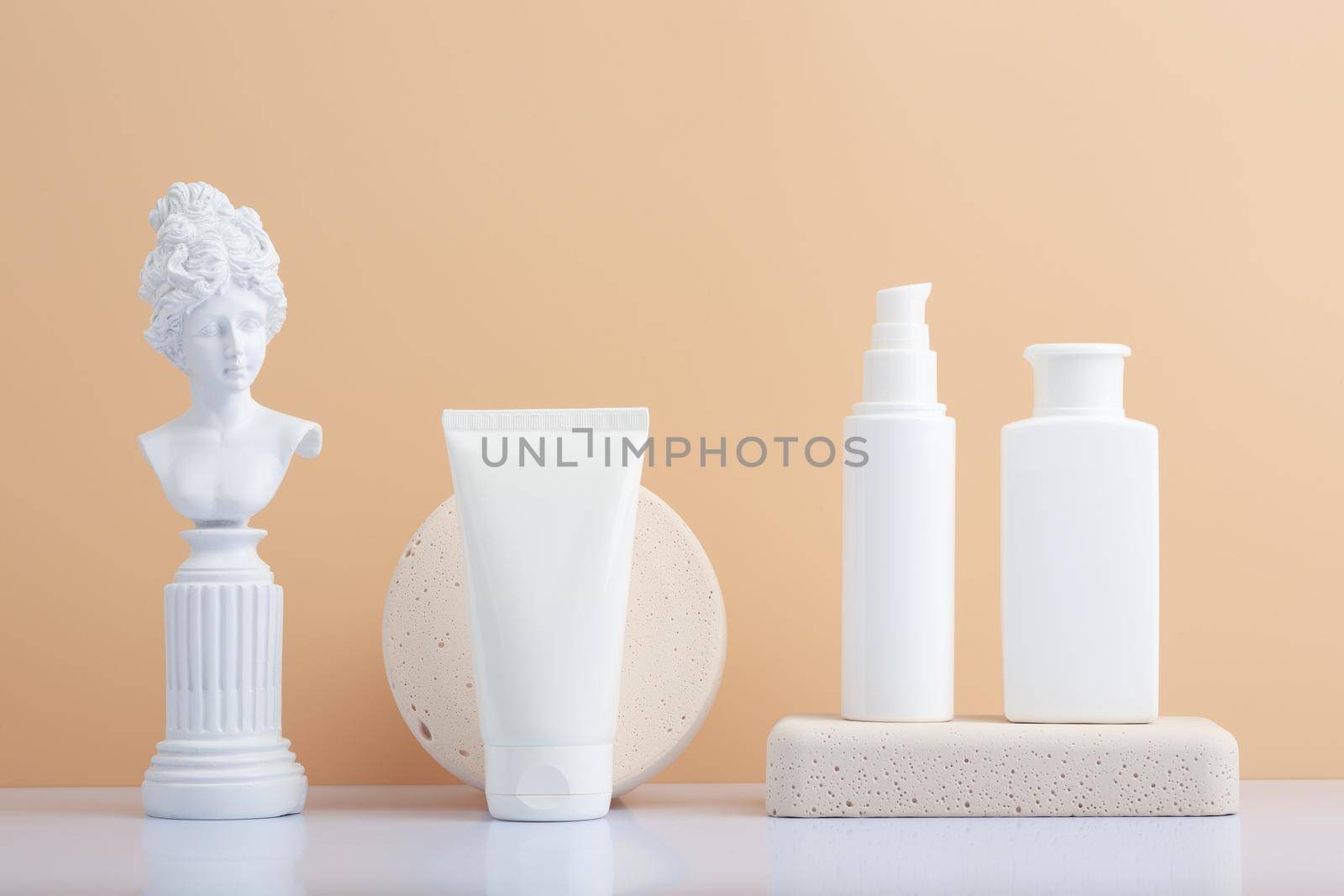 Set of skin care products with gypsum figure of a woman on white table against beige background by Senorina_Irina