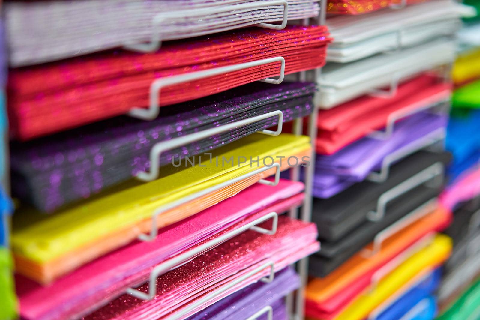 Sheets colored cardboard for designer creative works. Stacks multicolored drawing paper in the store. Colorful art papers on shelf for sale stationery store