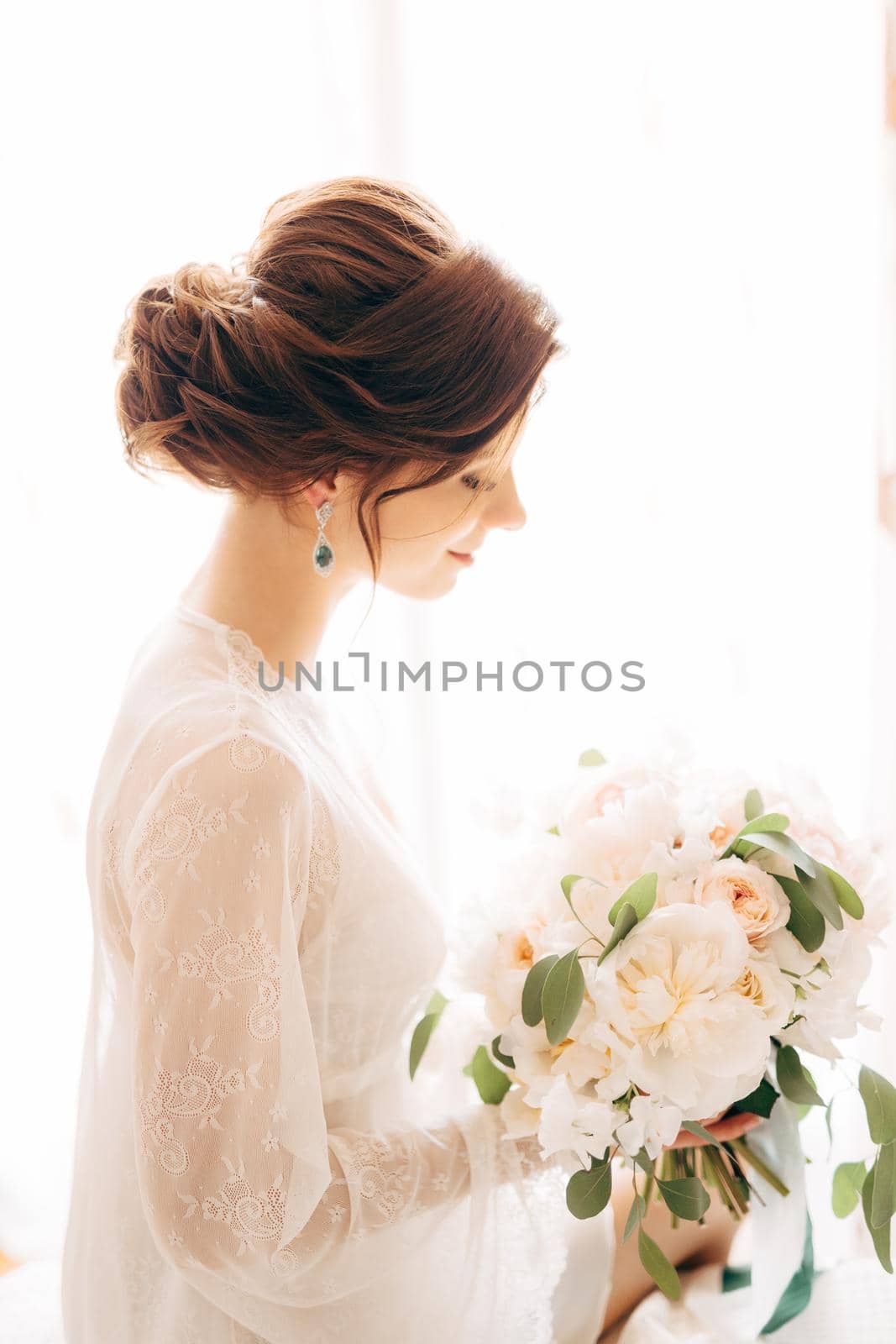 beautiful tender bride with bridal bouquet of cream roses and eucalyptus. High quality photo
