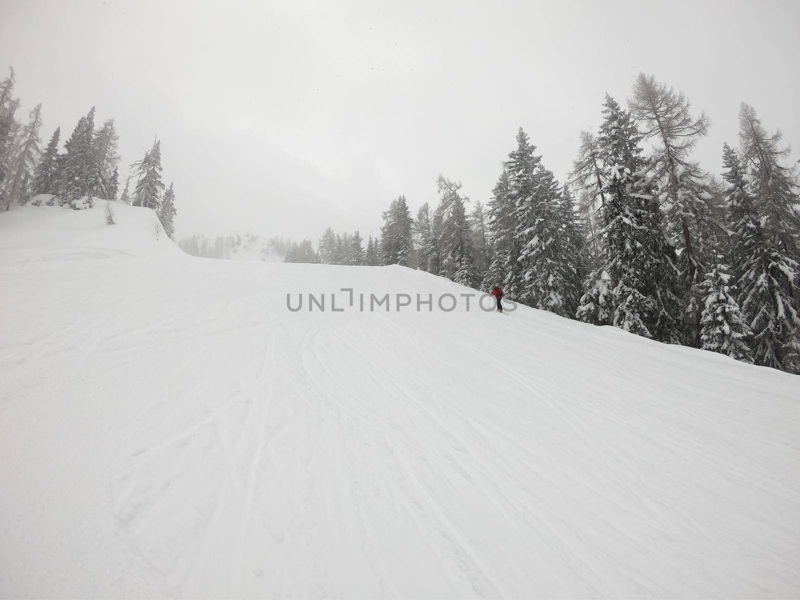 A man walking in the snow in the mountains.